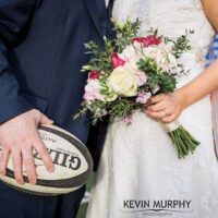 Bride and groom with rugby ball